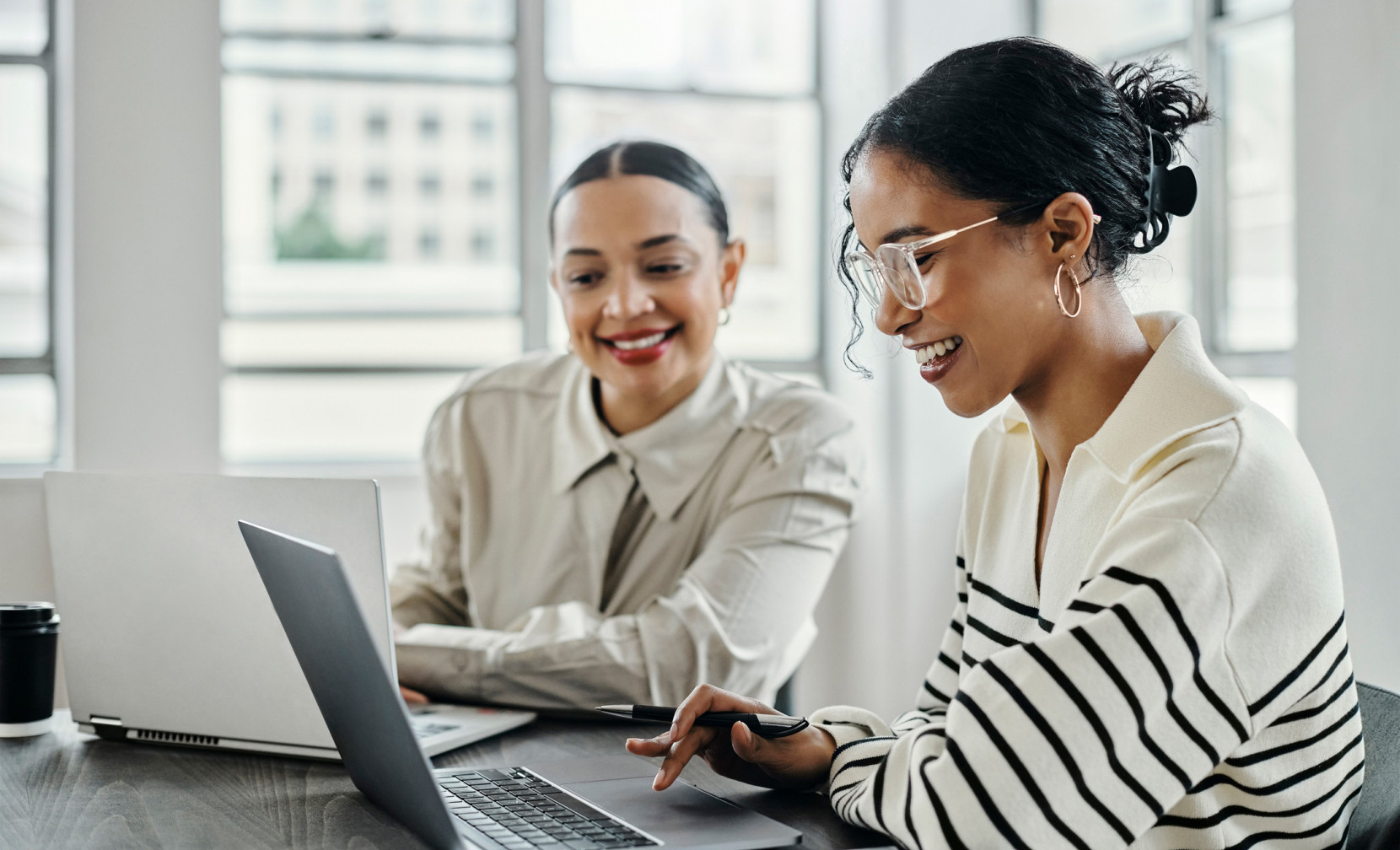 two women sat in front of a laptop screen